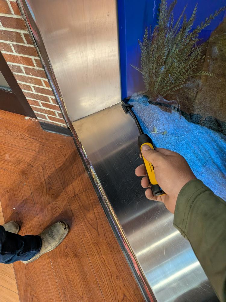 Technician measuring supply air at commercial ceiling vent