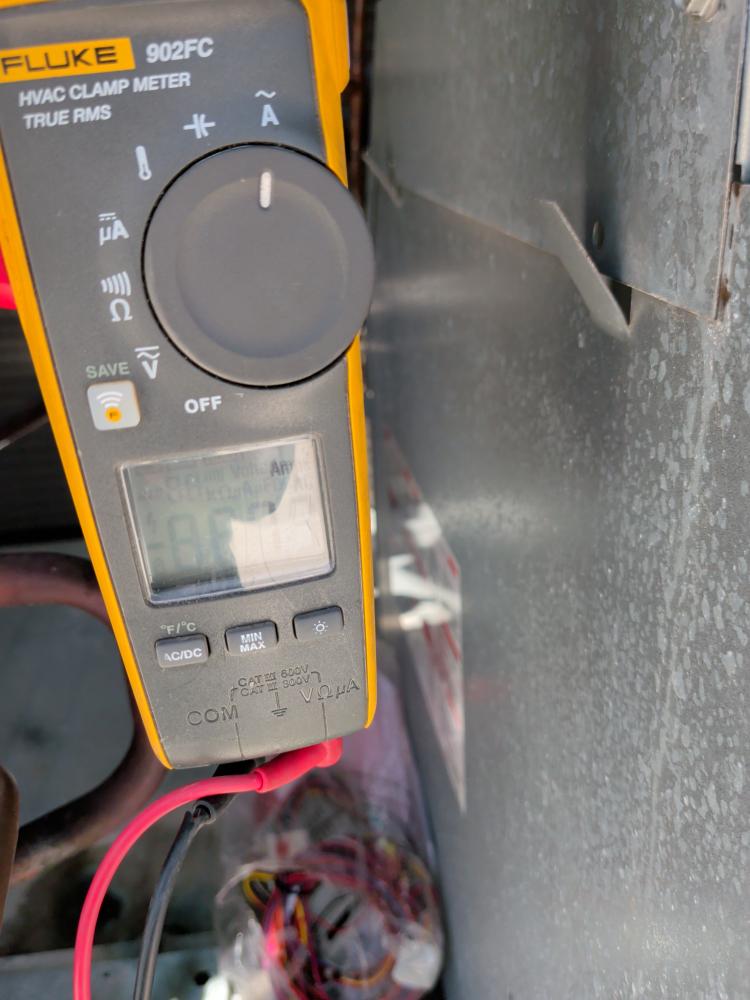 Electrical meter positioned beside rooftop unit wiring