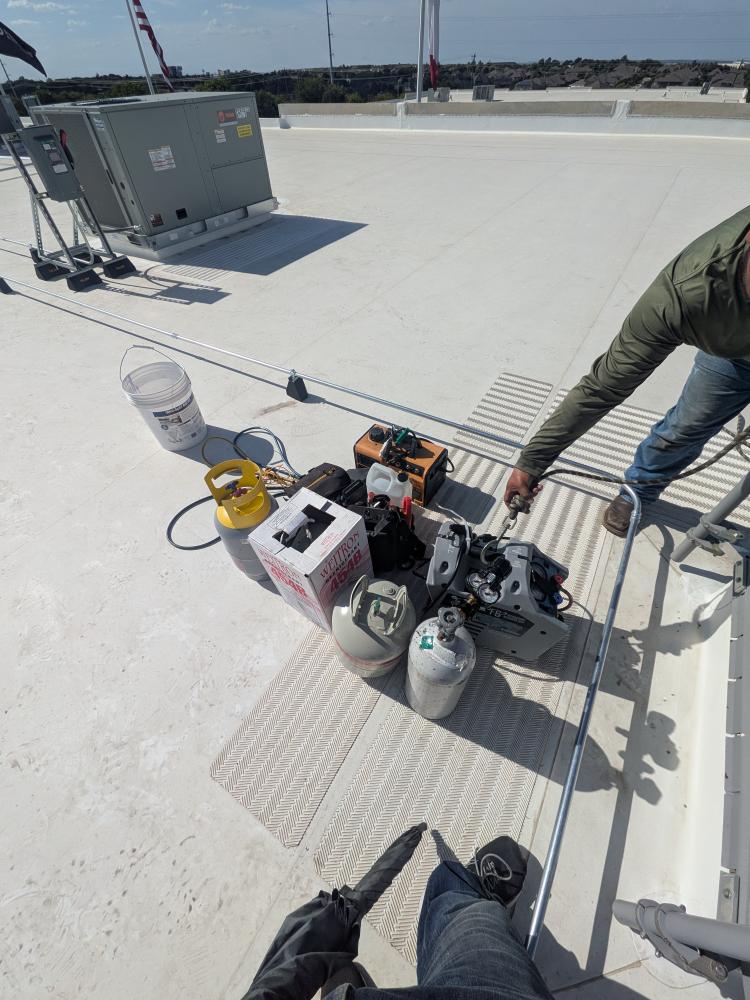 Technicians testing commercial rooftop HVAC system in Buda
